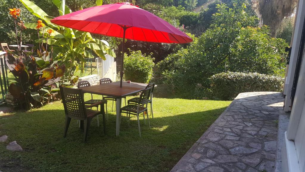 FolelliにあるChiapatellaの赤い傘下のテーブルと椅子
