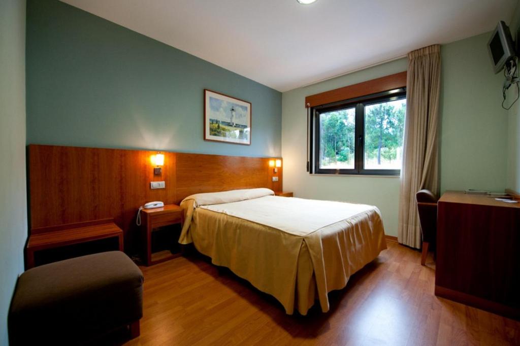 ポルトシンにあるHotel O Noso Portosinのベッドと窓が備わるホテルルーム