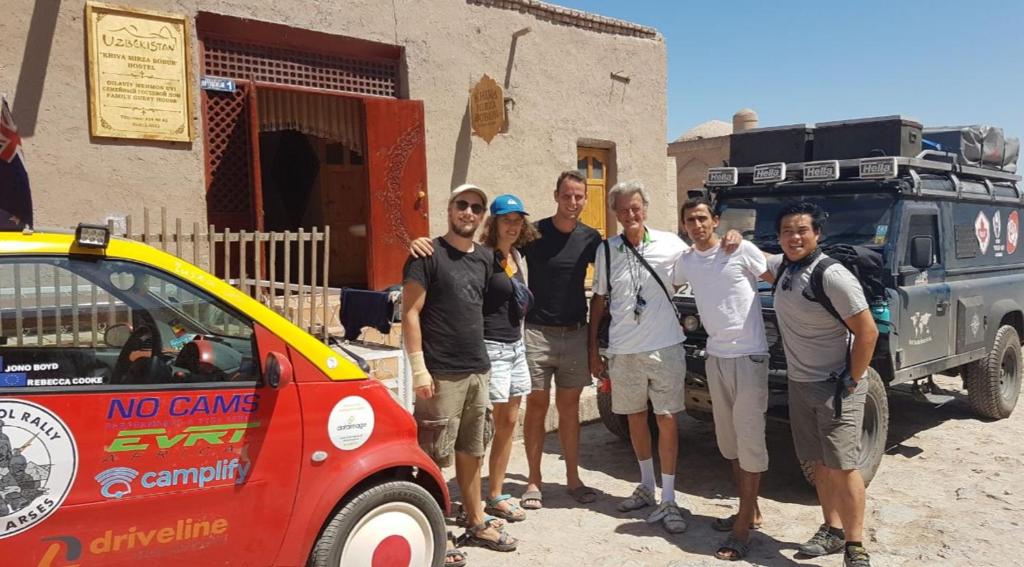 a group of people standing next to a small car at Khiva Mirza Bobur Guest House in Khiva