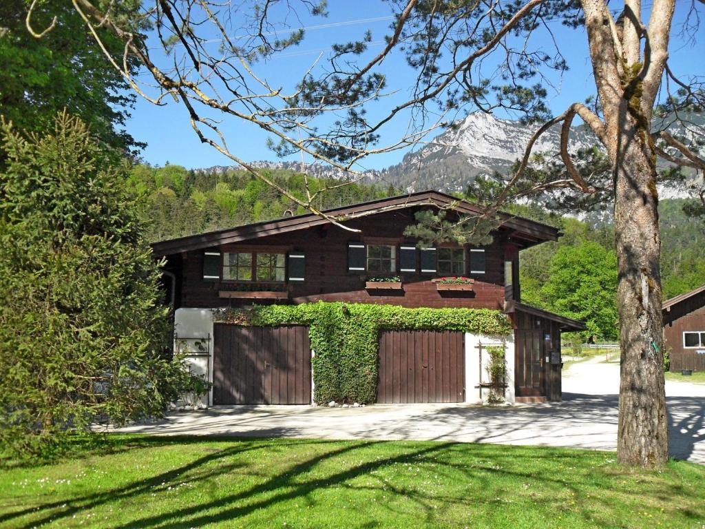 a house with a garage with a mountain in the background at Ferienhaus Gestüt Pfaffenlehen in Bischofswiesen