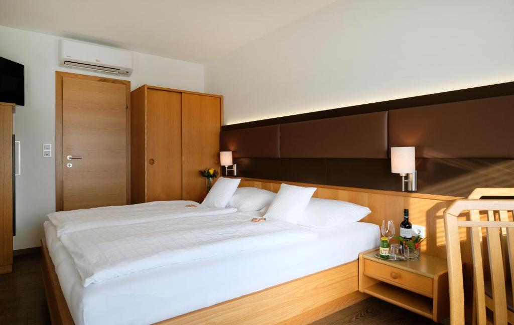 イルミッツにあるPension zur Sonneのベッドルーム(白い大型ベッド1台、木製ヘッドボード付)