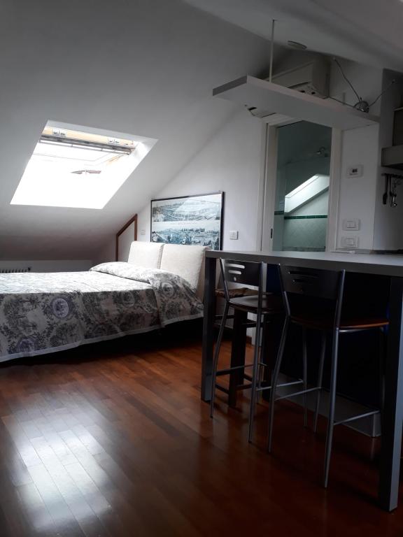 1 dormitorio con 1 cama y 1 mesa con sillas en La Mansardina del Giardinetto, en Oderzo