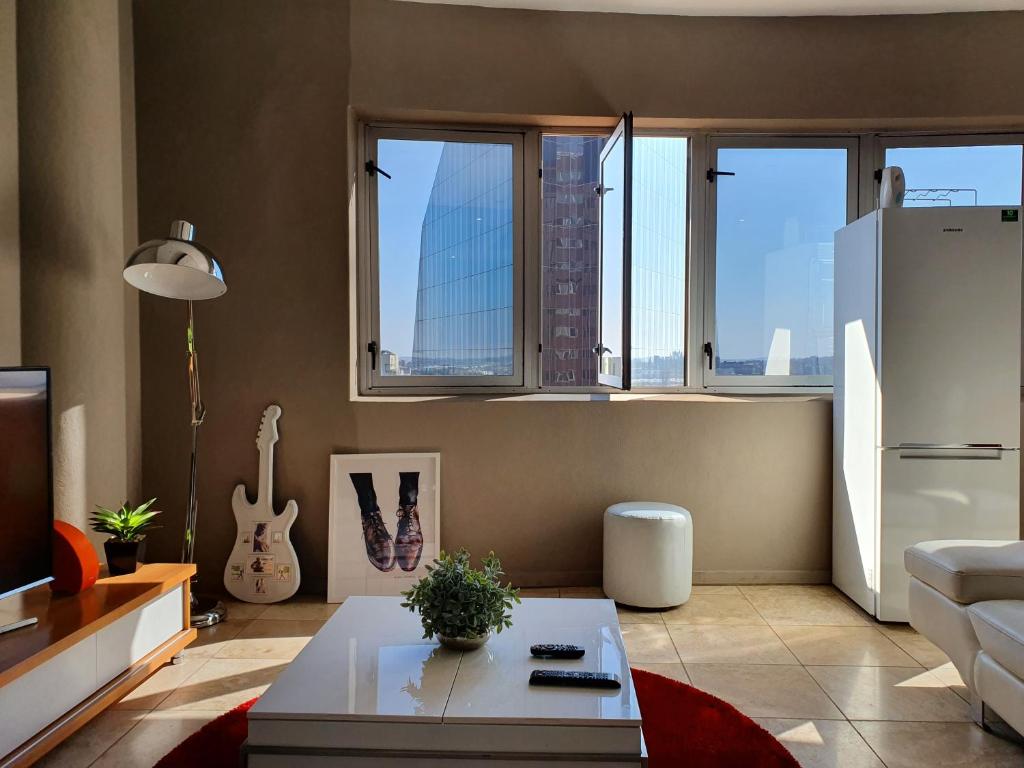 a living room with a couch and a refrigerator at Franklin Luxury Apartment in Johannesburg