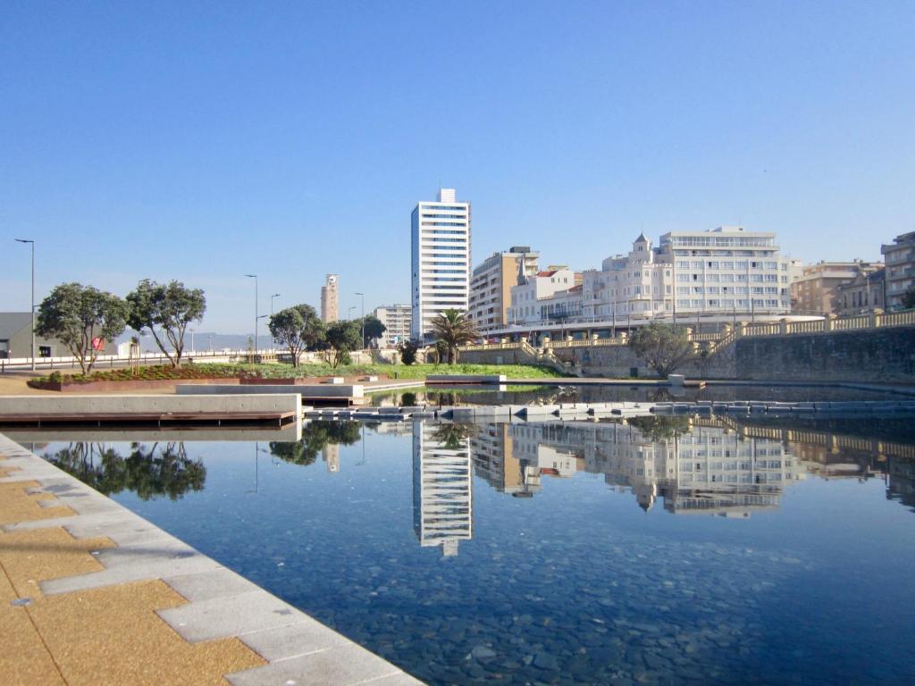 a large body of water with buildings in the background at Apartamento Praia do Relógio in Figueira da Foz