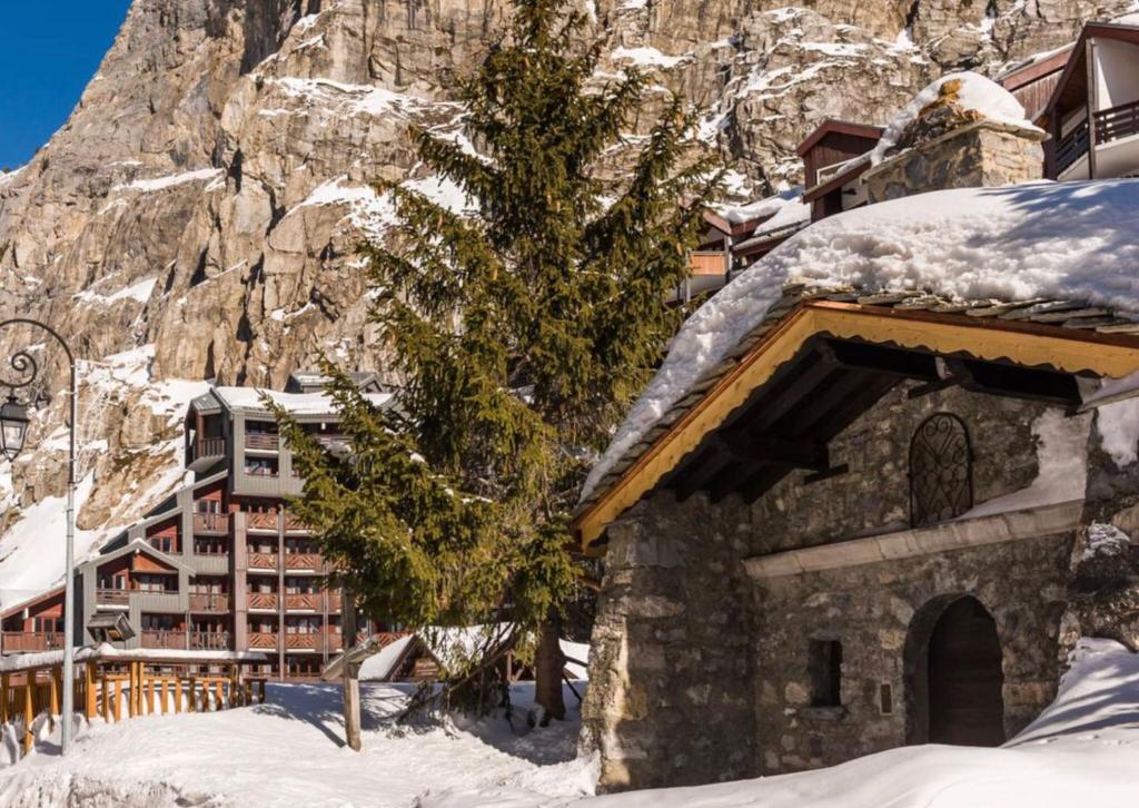 a building in the snow next to a mountain at Les Balcons de Bellevarde in Val-d'Isère