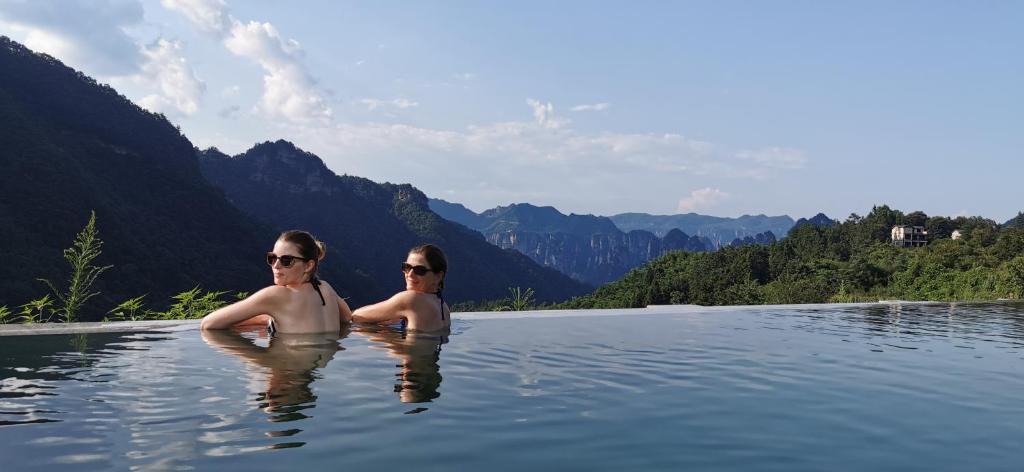 two women swimming in a body of water at Purespace --2nights 1pick-up&trip tickets&5min to park gate in Zhangjiajie