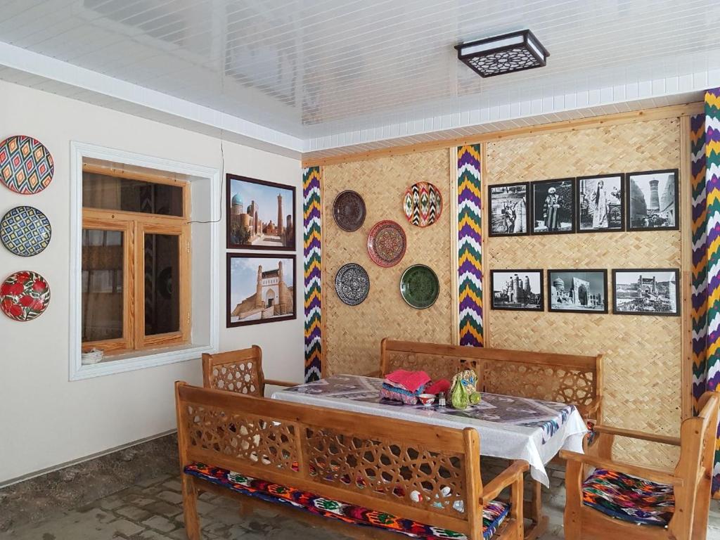 a dining room with a table and some plates on the wall at Guest house IBROHIM حلال in Bukhara