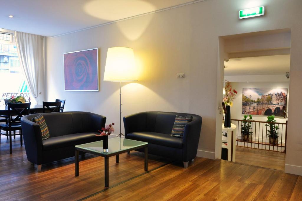 a living room filled with furniture and a coffee table at Hotel Residence Le Coin in Amsterdam