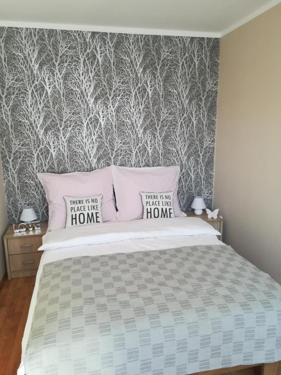 a bedroom with a bed with two pillows at Manta Apartamenty in Sianozety
