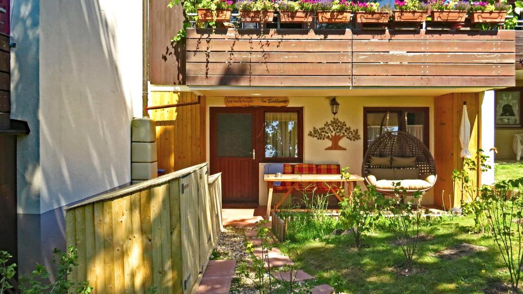 a small house with a patio and a chair on a porch at Apartment-Pension Im Eichenweg in Waldachtal