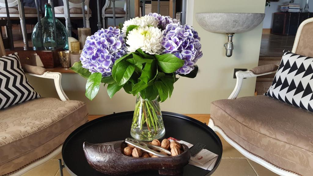 a vase with purple and white flowers on a table at Maison d hotes Lapitxuri in Arcangues