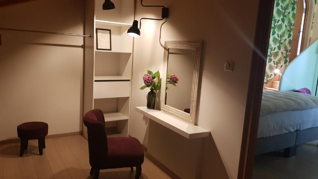 a room with a mirror and a chair and a bed at Maison d hotes Lapitxuri in Arcangues
