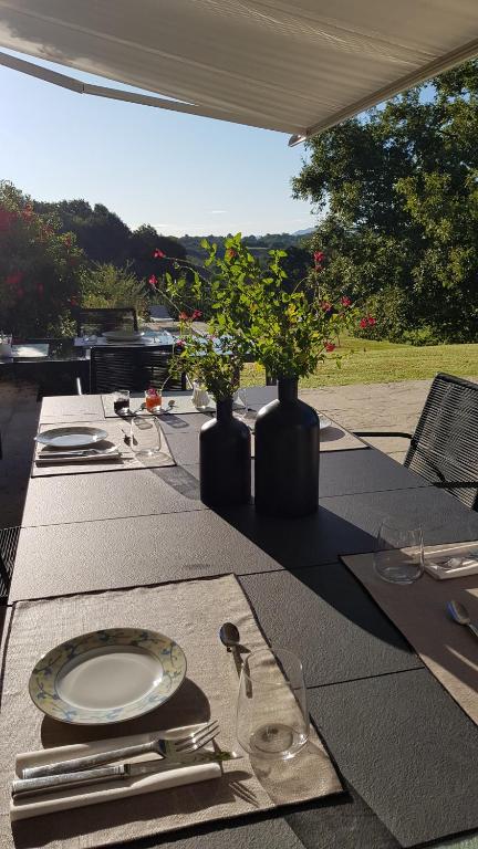 a table with plates and vases on top of it at Maison d hotes Lapitxuri in Arcangues