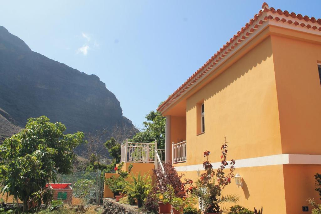a yellow building with a mountain in the background at Casa Gloria in Valle Gran Rey