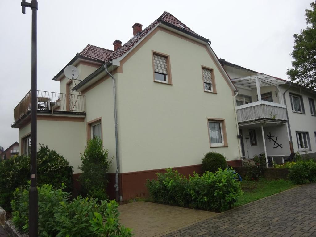 a white house with a balcony on a street at Private Ferienwohnung Lan in Bad Rothenfelde