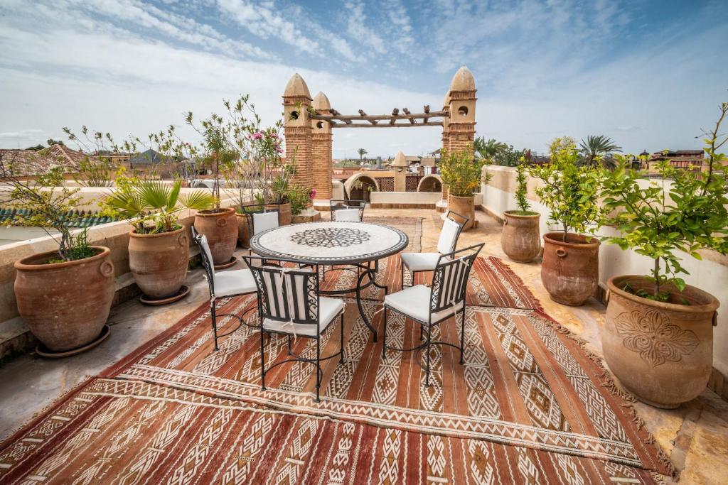 a patio with a table and chairs on a rug at Riad Adilah Marrakech - by EMERALD STAY in Marrakesh