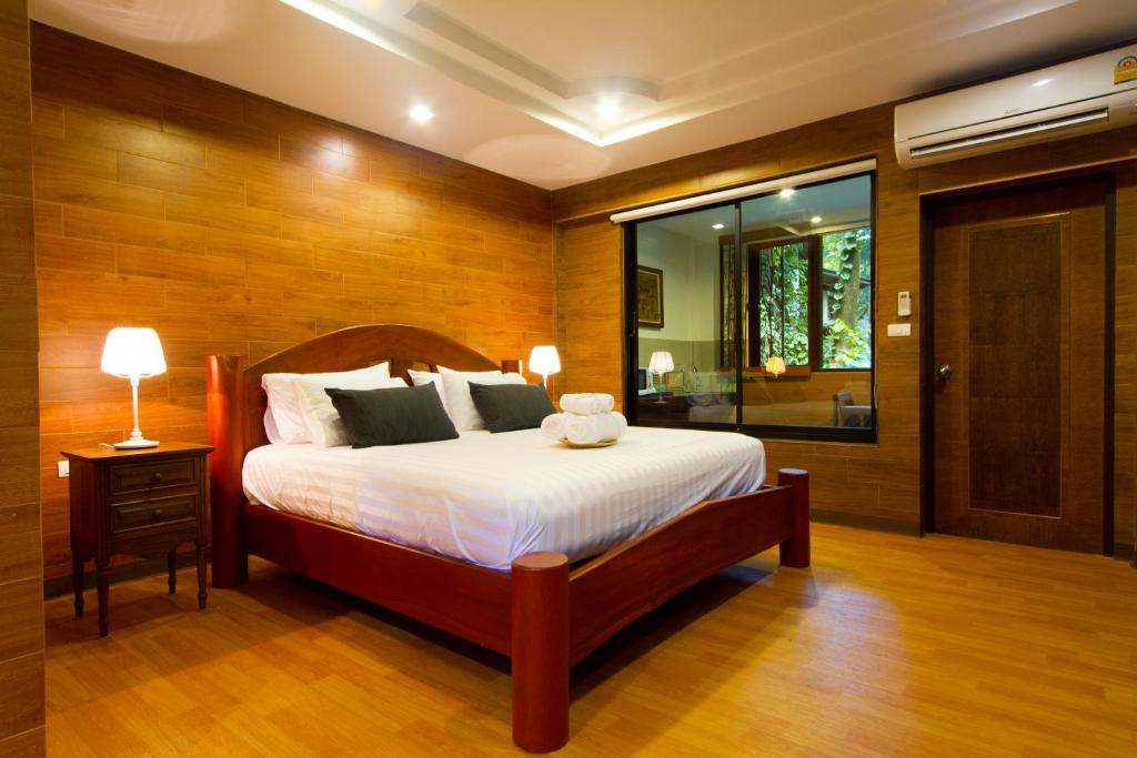 een slaapkamer met een groot bed en een raam bij Namtok Sarika Resotel in Nakhon Nayok