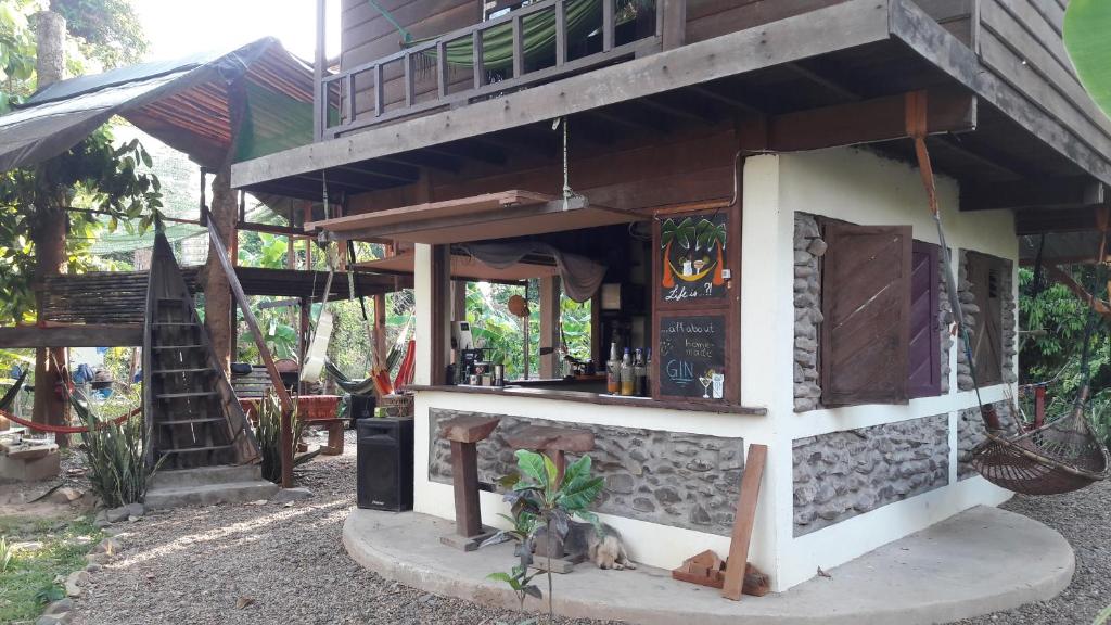 a building with a bar on the side of it at Rudi Mental Holiday Lodge in Don Det