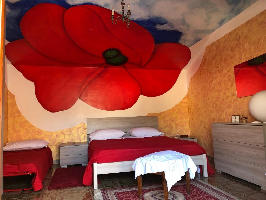 a bedroom with a red flower painted on the wall at Bed and Breakfast IL CAVALIERE in Pozzilli