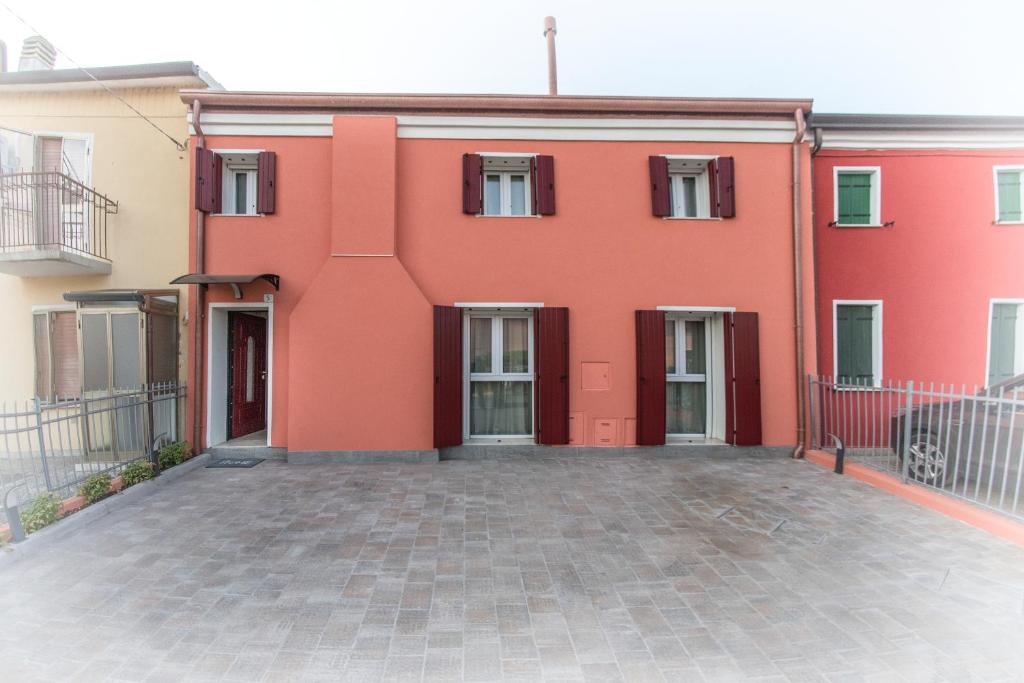 un edificio rojo con un patio delante de él en ALL'ANTICO CAMPANILE en Rovigo