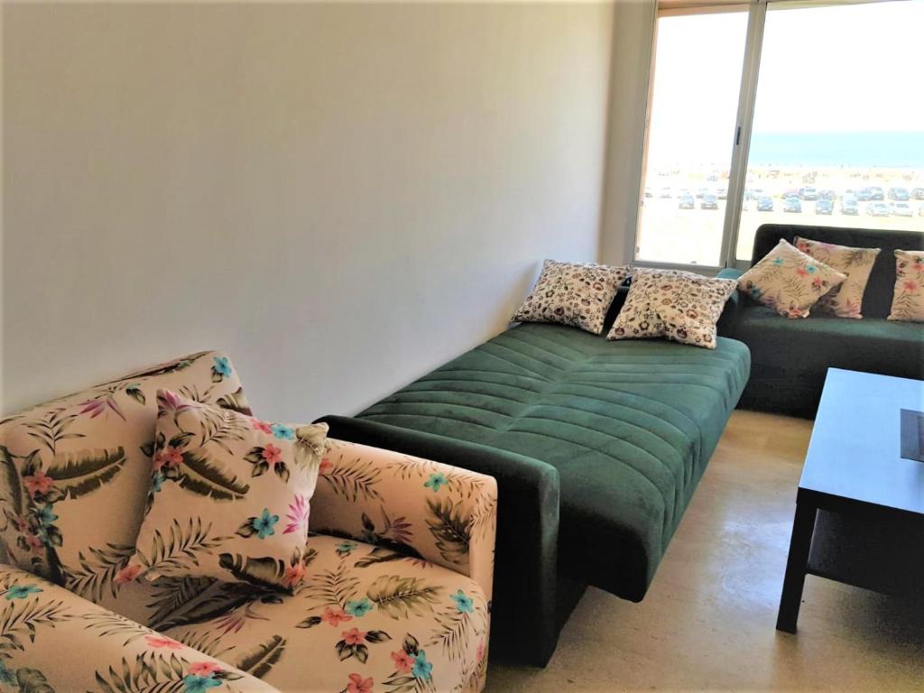 Plage de rêve في Agadir nʼ Aït Sa: غرفة معيشة مع أريكة وكرسي