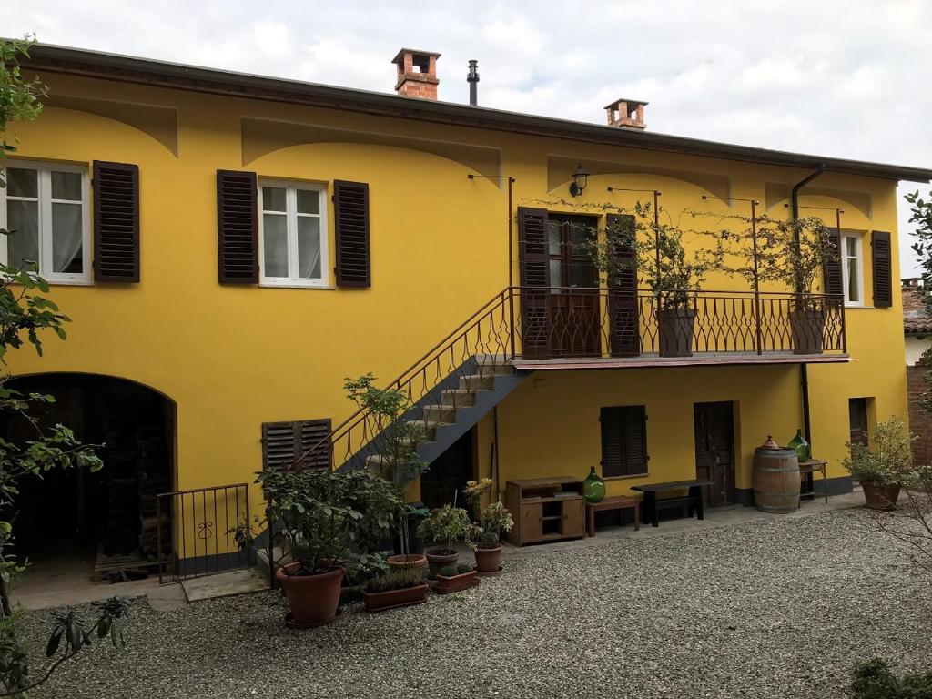 Casa amarilla con balcón y escalera en Noi Due Guest House - Fubine Monferrato, en Fubine