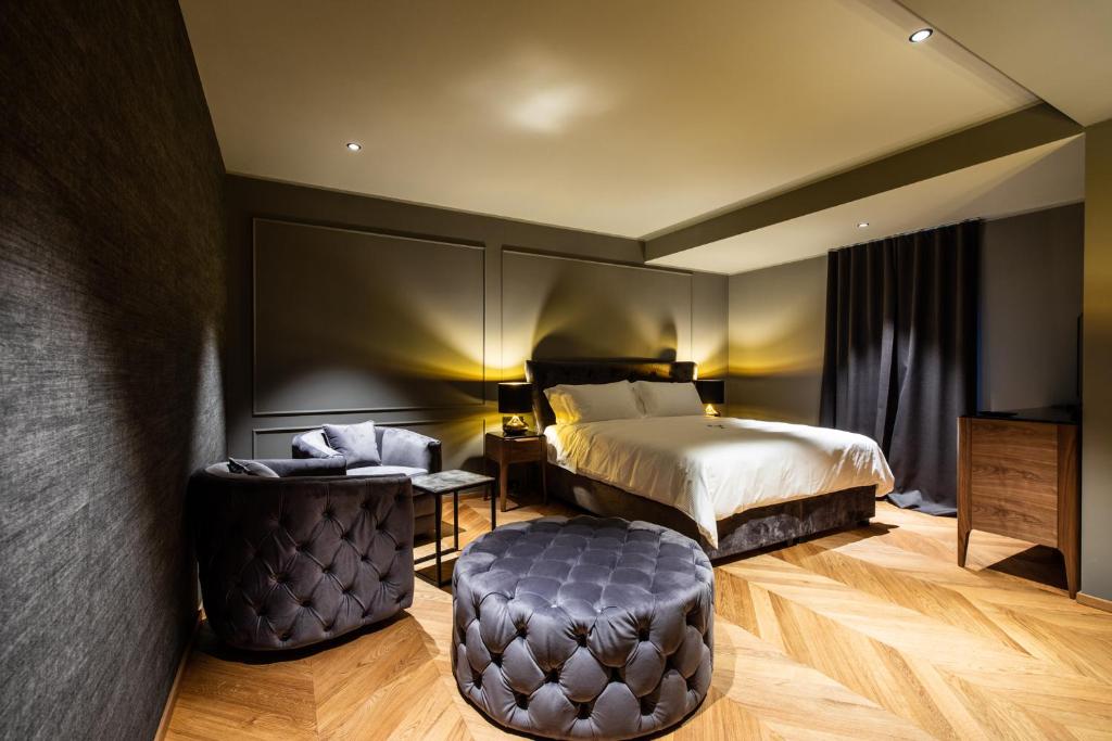 um quarto de hotel com uma cama e um banco em DAM boutique hotel & restaurant em Nova Gorica