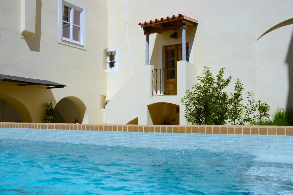 a villa with a swimming pool in front of a house at Casa Morgado Esporao in Évora