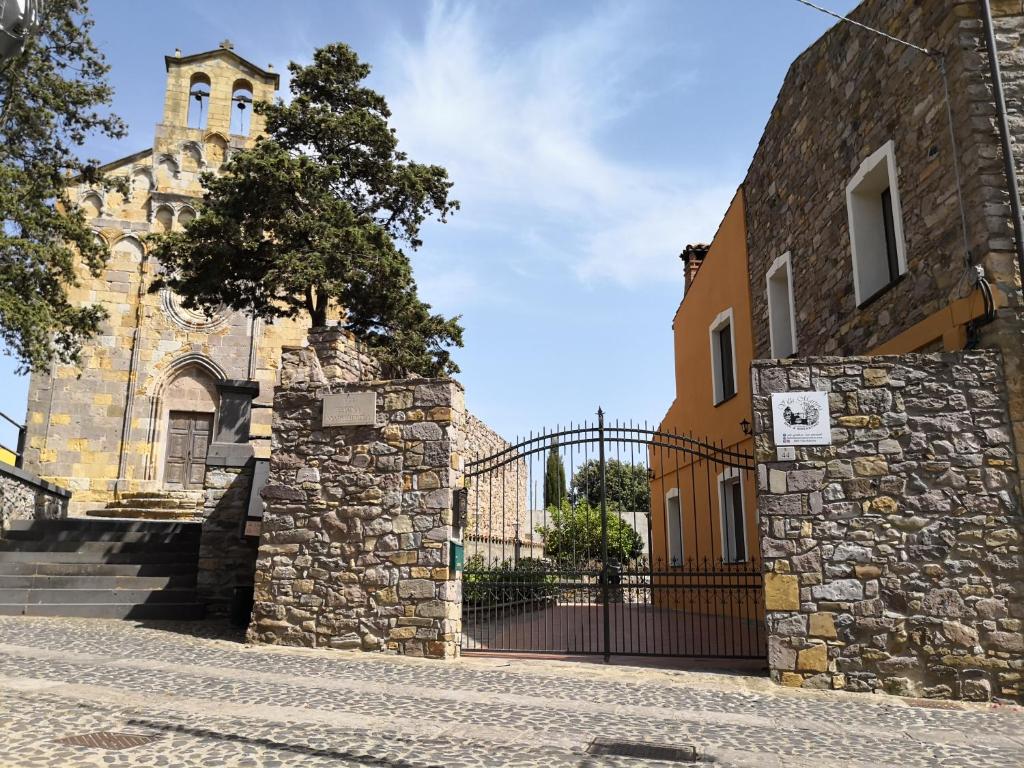 a building with a gate and a church at B&B Villa Martina in Sardara