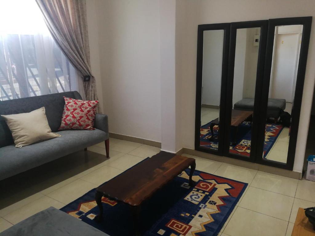 een woonkamer met een bank en een spiegel bij Campafela Guest House in Johannesburg