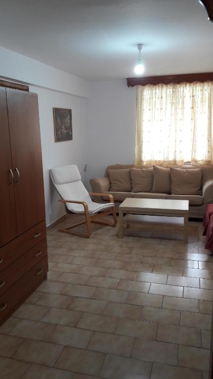 uma sala de estar com um sofá e uma mesa em Anastasia' s guest house em Neos Marmaras