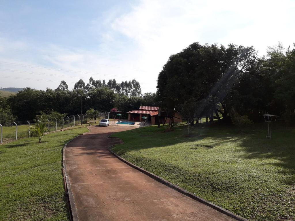 a dirt road next to a field with a house at Recanto do Nenê in Botucatu