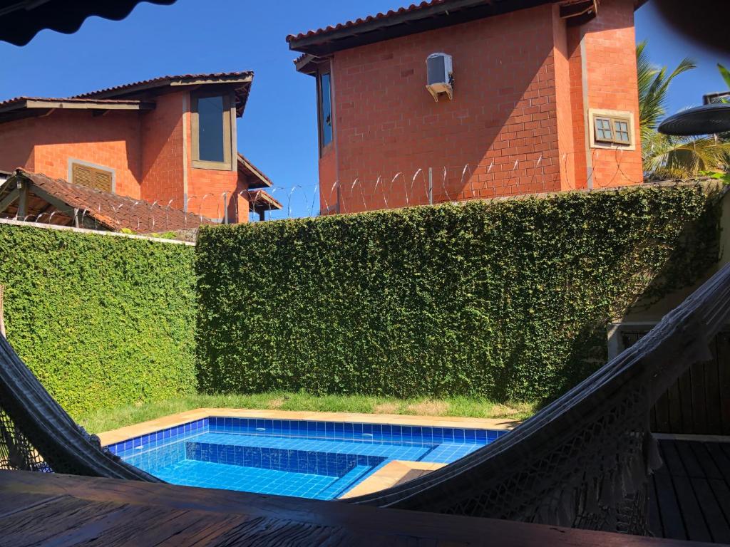 una piscina frente a un seto verde en Casa com Piscina Aquecida Privativa en Juquei