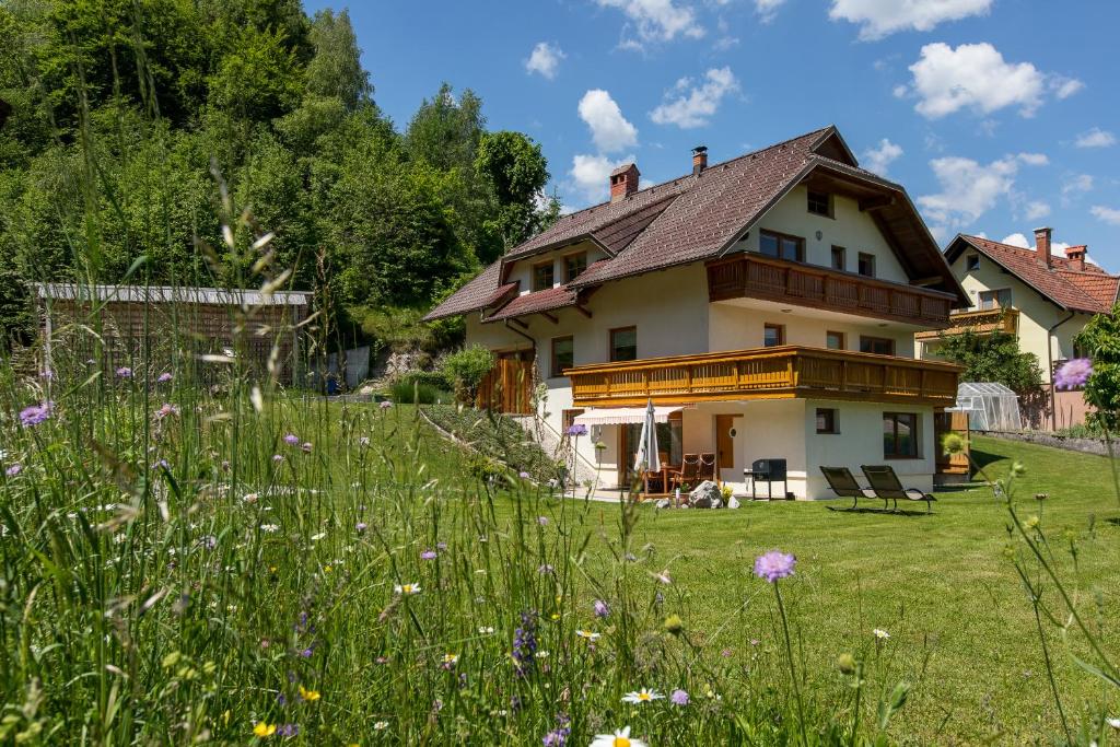 una casa con un campo de hierba y flores en Apartment Natur, en Bled