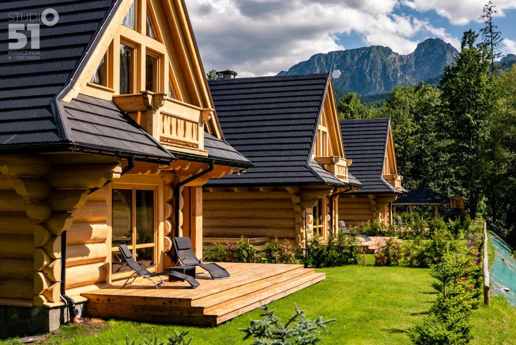 une cabane en rondins avec une terrasse dans la cour dans l'établissement Osada nad potokiem, à Kościelisko