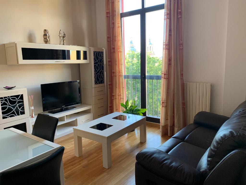 un soggiorno con divano e tavolo di Cozy apartment Plaza del Pilar - San Felipe a Saragozza