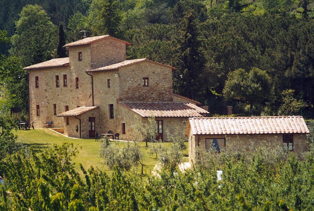 un gran edificio de piedra con árboles en el fondo en Frateria Di San Benedetto, en Montepulciano