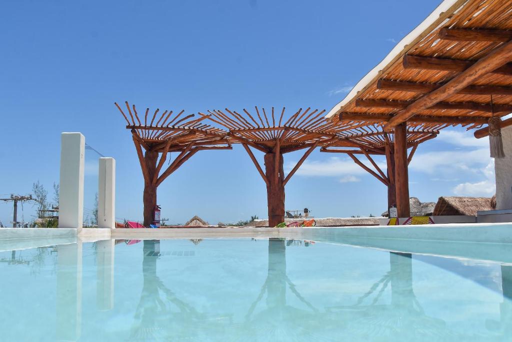a swimming pool with a wooden pergola at Soho Boutique Holbox - Adults Only in Holbox Island