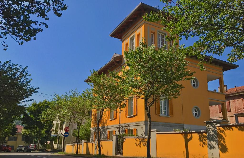 un edificio naranja en una calle con árboles delante en LIBERTY ROOM AND BREAKFAST, en Borgo Val di Taro