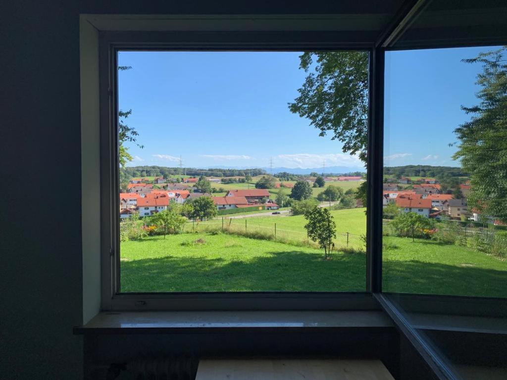 una ventana con vistas a un campo verde en Zimmer mit Bergblick en Starnberg