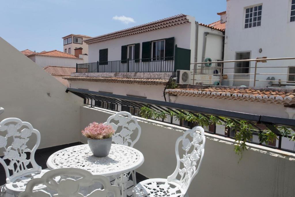 a white table and chairs on a balcony at Antonella Home Funchal in Funchal