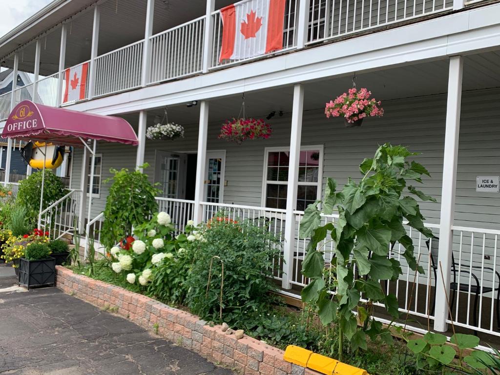 um edifício com flores e plantas em frente em Midtown Motel & Suites em Moncton