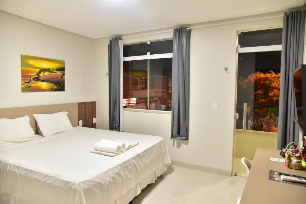 a bedroom with a white bed and a window at Hijo Buriti Hotel in Mauriti