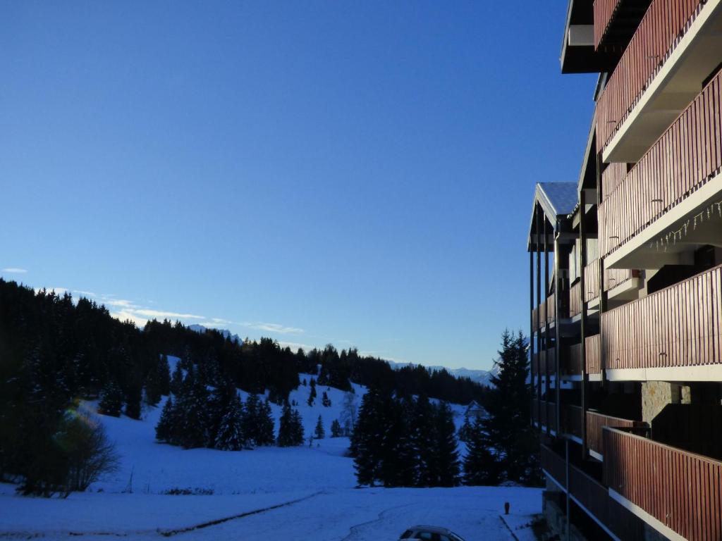 a view of a snow covered mountain from a building at Le Génépi in Taninges