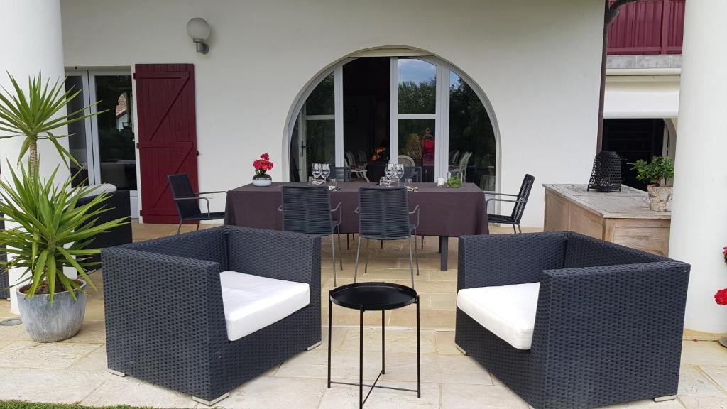 a patio with a table and chairs in a building at Maison d hotes Lapitxuri in Arcangues