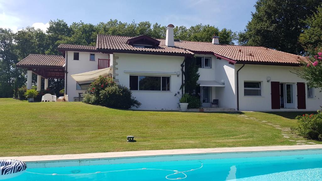 a house with a yard and a swimming pool at Maison d hotes Lapitxuri in Arcangues
