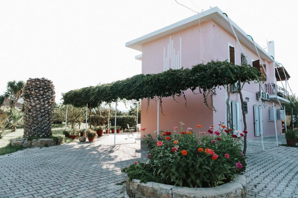 a pink house with flowers in front of it at Jerry Apartments in Svoronata