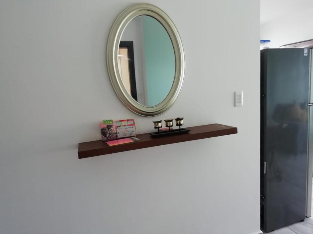 ein Spiegel an einer Wand neben einem Regal in der Unterkunft Edificio Nancabez III in Tonsupa