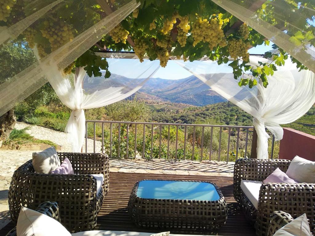 a porch with chairs and a view of the mountains at Quinta Vale de Carvalho in Pinhal do Douro