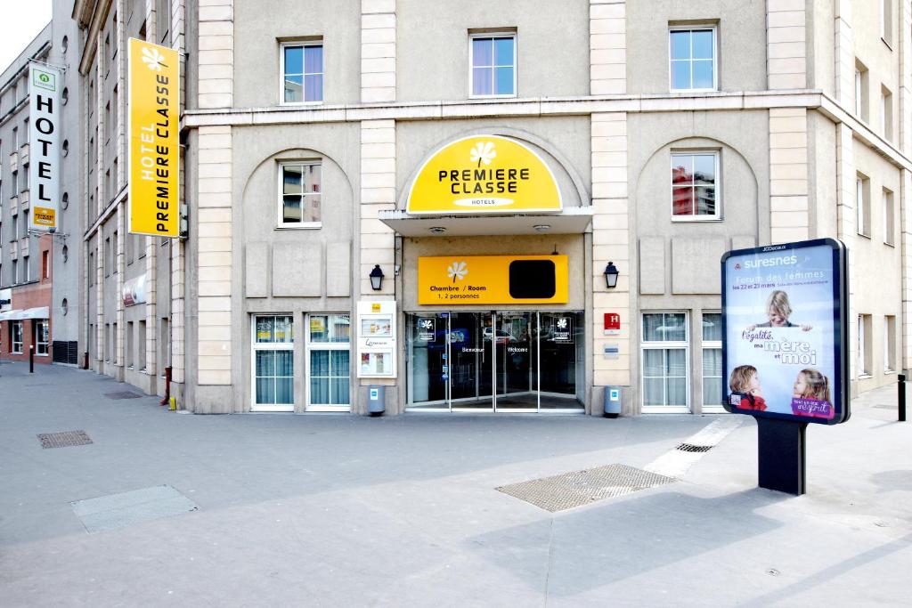 a large building with a sign in front of it at Premiere Classe Paris Ouest Pont De Suresnes in Suresnes